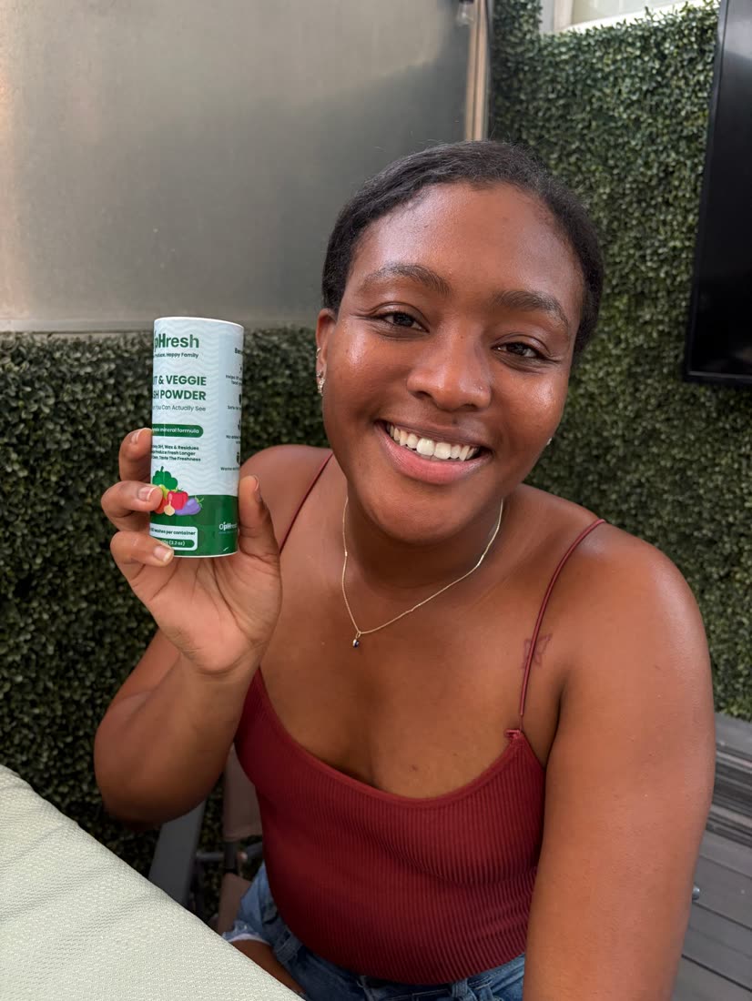 A smiling customer holding the O'pHresh canister beside her face